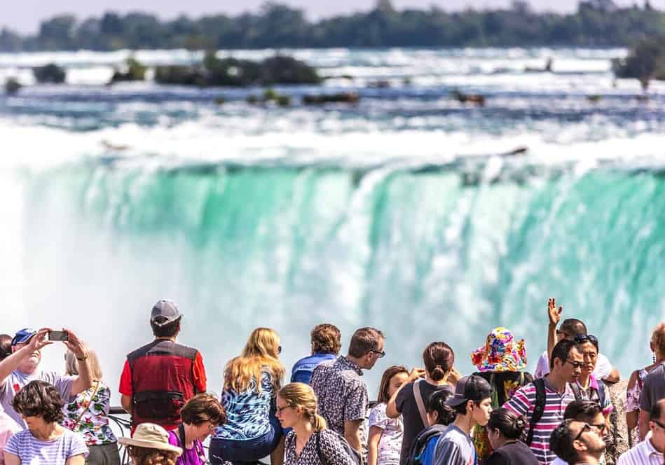 Tourists overlook the Horseshoe Falls in Niagara Falls, Ontario. With combined visitors to the Canadian and American side of the border, Over 20 Million Tourists Visit Niagara Falls Each Year.