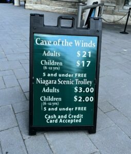 Sandwich board with cave of the Winds and niagara Falls Scenic Trolley Prices